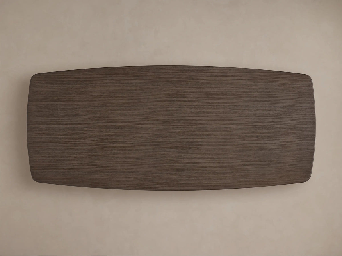 Close-up of the Saint Germain Wood Dining Table's dark brown oak tabletop, showing rich wood grain and a softly rounded edge.