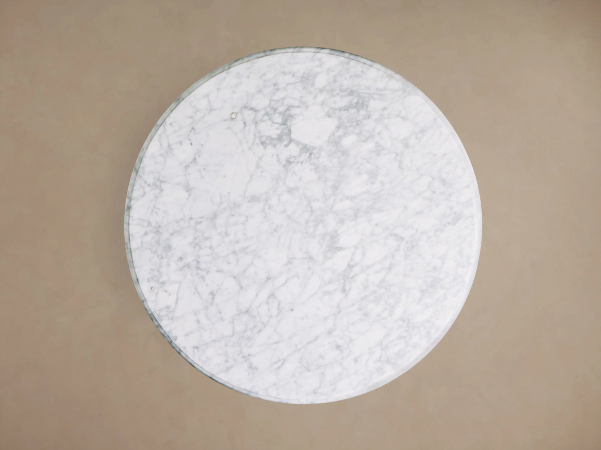 Front view of the Clemence Bistro Table with a white Carrara marble top and a brass-toned tulip-style pedestal base.