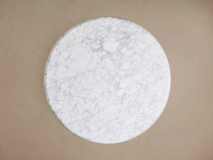 Front view of the Clemence Bistro Table with a white Carrara marble top and a brass-toned tulip-style pedestal base.