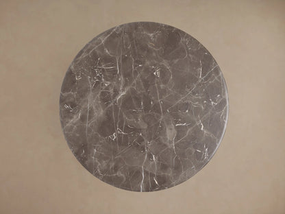 Overhead view of the round, dark gray marble top of the Clemence Bistro Table, showing intricate white veining patterns.