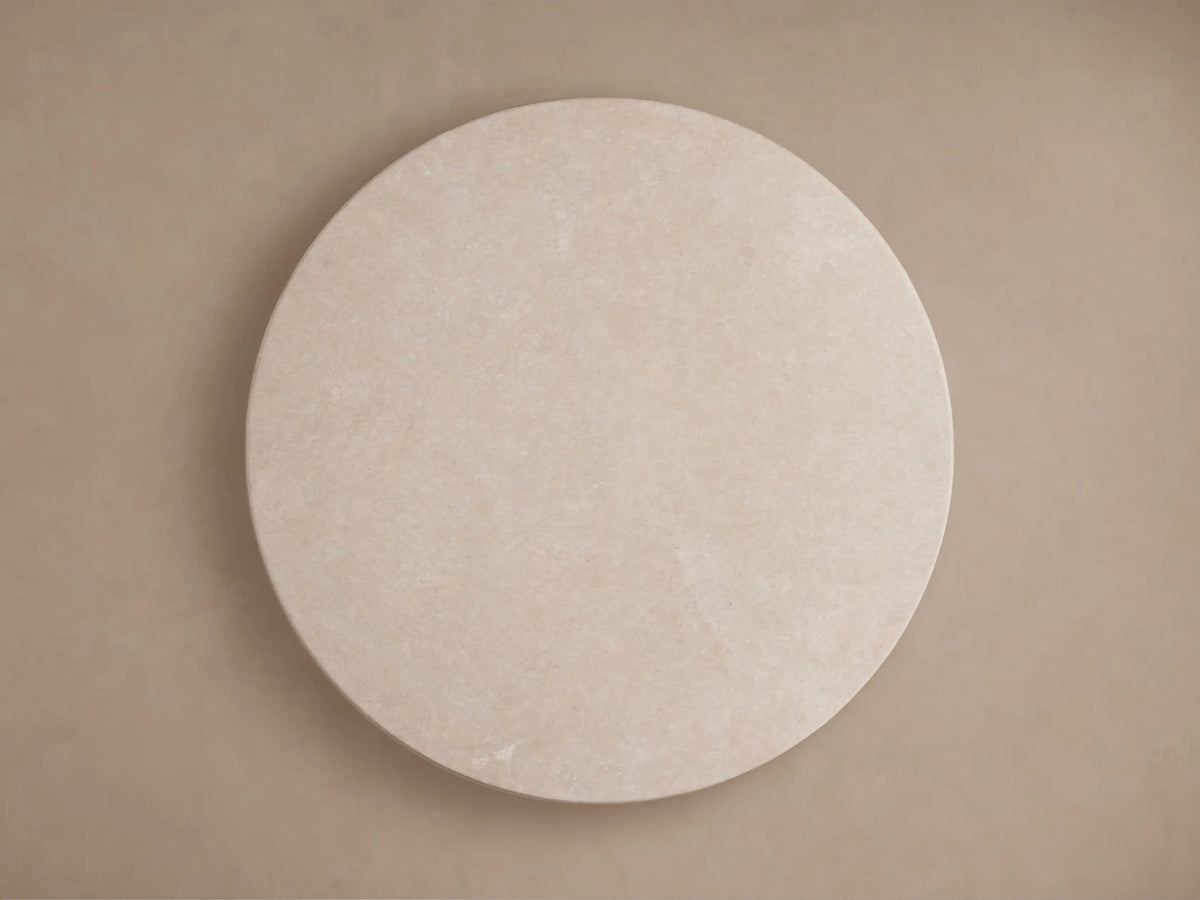 Close-up of Saint Germain Round Stone Dining Table's cream marble top, showcasing natural patterns and a smooth finish.