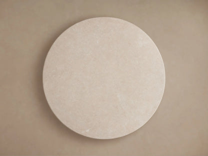 Close-up of the Saint Germain Round Stone Dining Table's creamy marble top, showing subtle natural veining and variations.