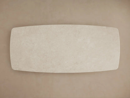 Close-up of Saint Germain Stone Dining Table's cream marble top, showing subtle veining and a smooth, rounded corner.