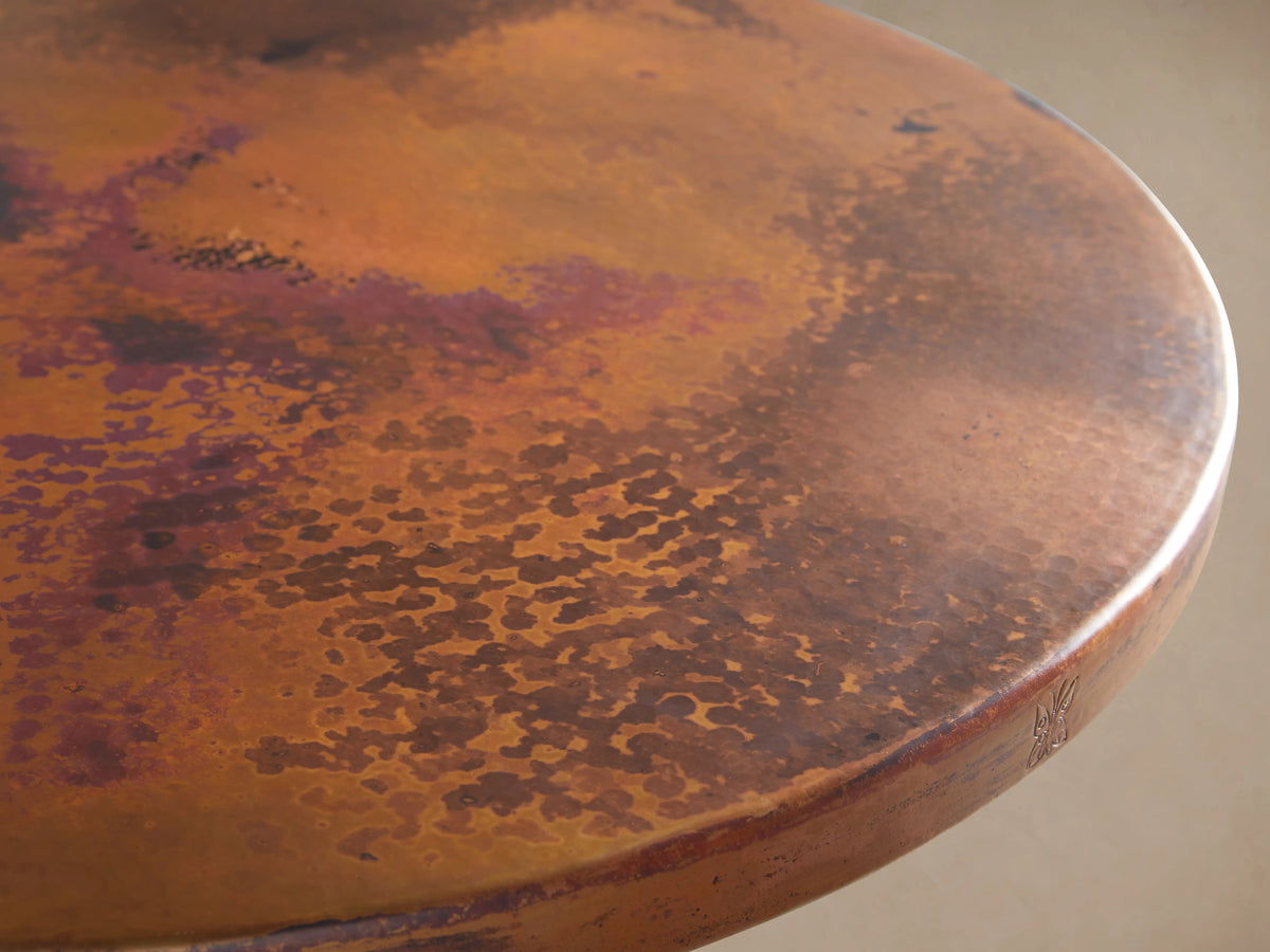 Recycled Metal Bar Table with Wade Base featuring a round, rust-toned tabletop with unique copper patterns and smooth edge detailing.