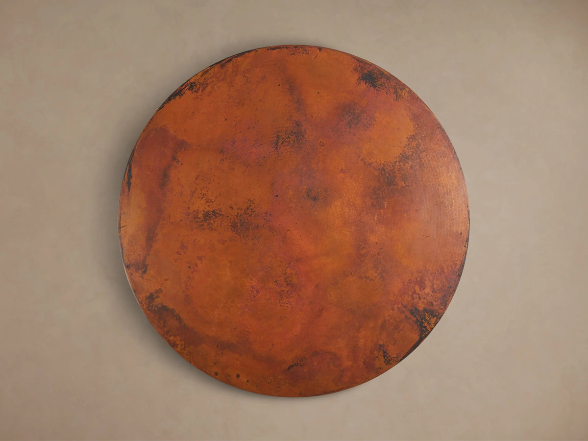 Recycled Metal Bistro Table with hammered copper top, warm orange and dark brown distressed patina. Intricate butterfly detail on edge.