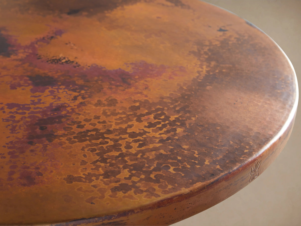 Recycled Metal Counter Table with Wade Base, featuring a round copper top and a sturdy dark iron pedestal base.