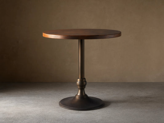 Recycled Metal Counter Table with Wade Base, featuring a round copper top and a sturdy dark iron pedestal base.