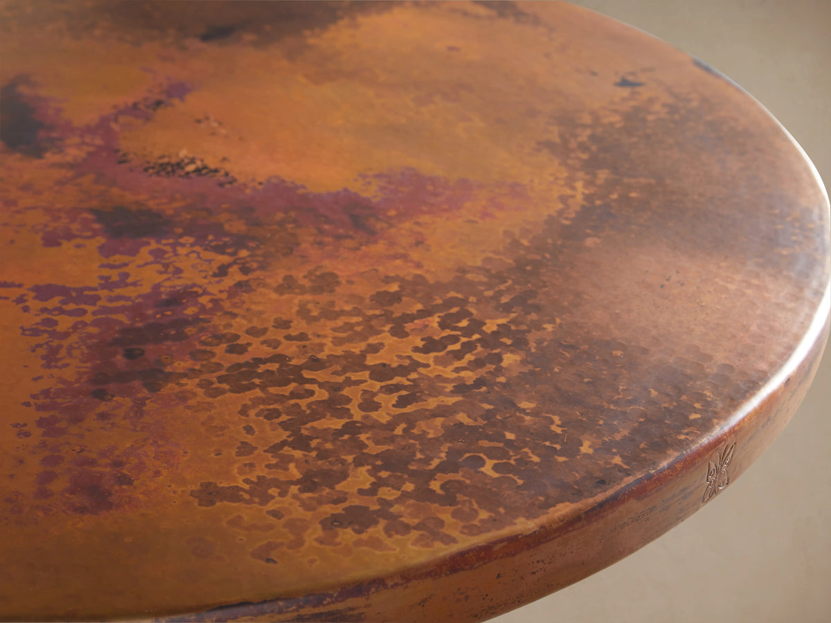 Recycled Metal Bar Table with Wade Base featuring a round wooden tabletop and black iron pedestal base on a wooden floor.