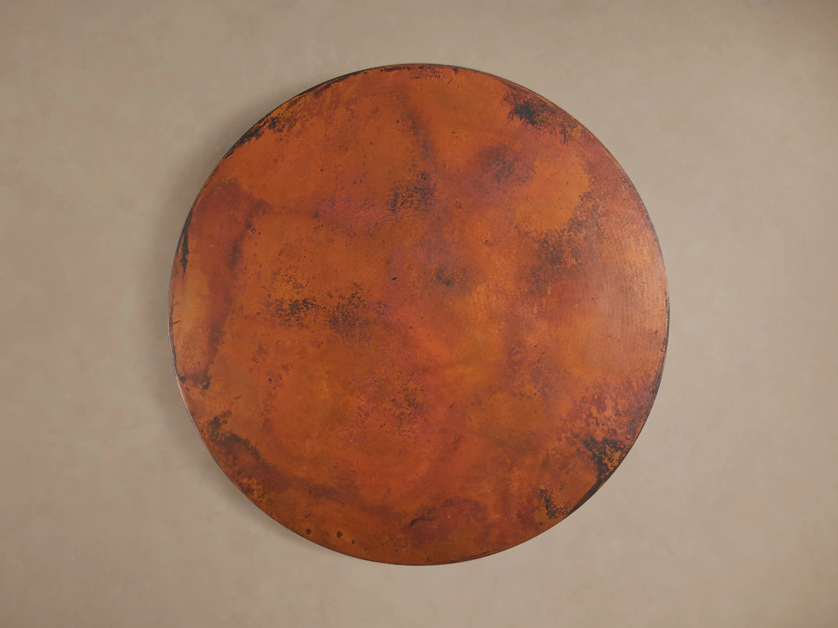 Detailed view of the Recycled Metal Bistro Table's Wade Base, showing its dark, aged bronze, circular metal with a speckled finish.