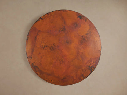 Detailed view of the Recycled Metal Bistro Table's Wade Base, showing its dark, aged bronze, circular metal with a speckled finish.