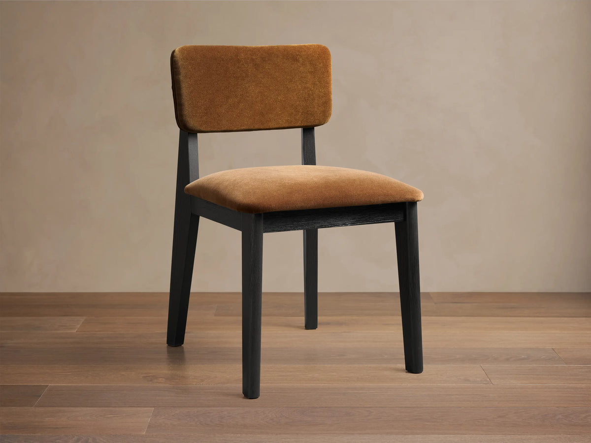 Front view of the Corrado Dining Side Chair with a dark ash wood frame and golden brown upholstered seat and backrest.