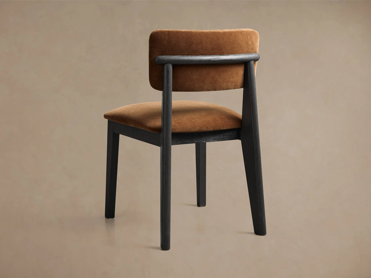 Rear view of the black ash wood Corrado Dining Side Chair with brown upholstered seat and back, featuring a horizontal backrest bar.
