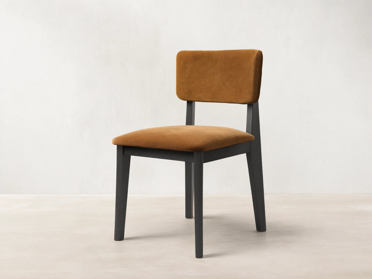 Front view of the Corrado Dining Side Chair with a dark ash wood frame and golden brown upholstered seat and backrest.