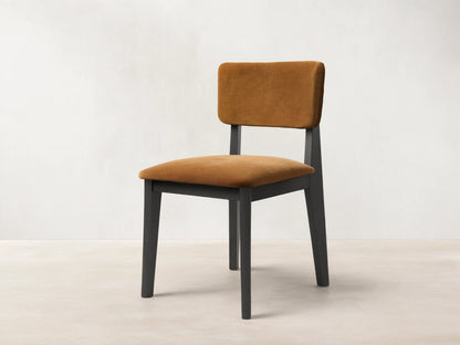 Front view of the Corrado Dining Side Chair with a dark ash wood frame and golden brown upholstered seat and backrest.