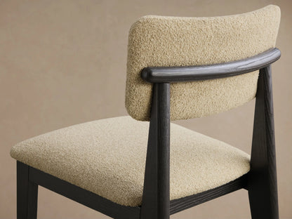 Front view of a dark ash wood Corrado Dining Side Chair with a textured beige upholstered seat and back.