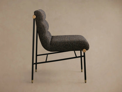Close-up of a chair back with multi-tonal brown bouclv© upholstery, dark brown leather straps, and natural wooden dowels.