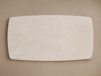 A close-up of the Saint Germain Stone Dining Table corner showing the cream marble surface with natural variations against a neutral background.