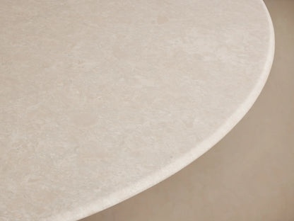 Saint Germain dining table with a round white marble top and a dark wood base, set on a wooden floor against a neutral wall.