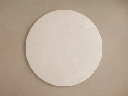 Saint Germain round dining table with cream marble stone top, showing smooth surface and natural variations in pattern.