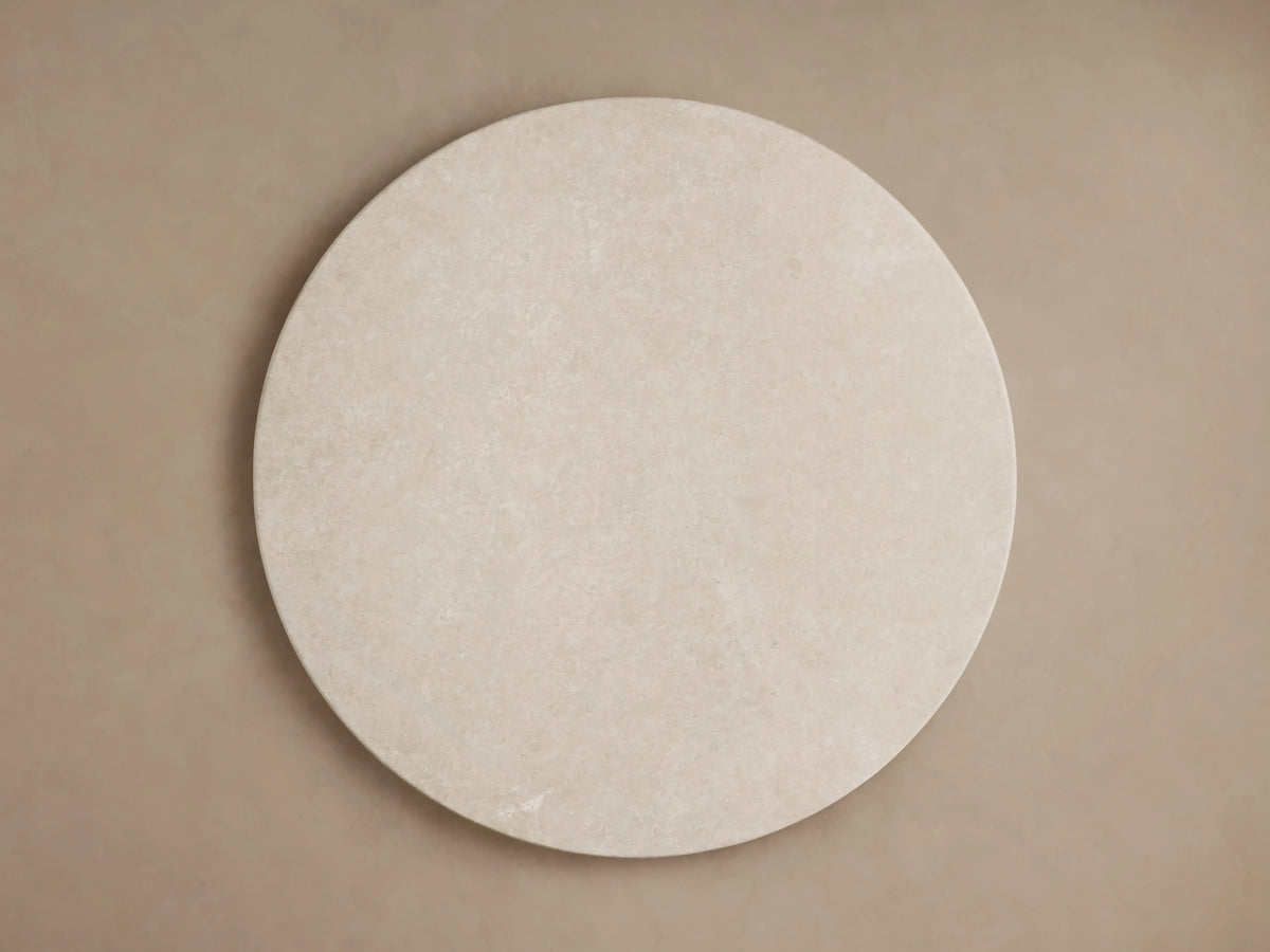Round edge of the Saint Germain Dining Table with a smooth, cream marble surface, subtle veining visible.