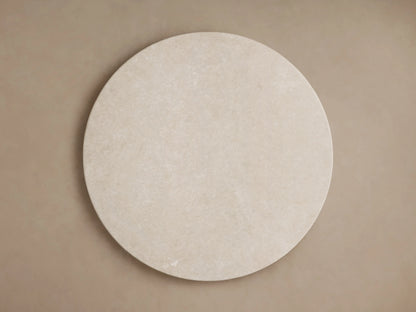 Round edge of the Saint Germain Dining Table with a smooth, cream marble surface, subtle veining visible.