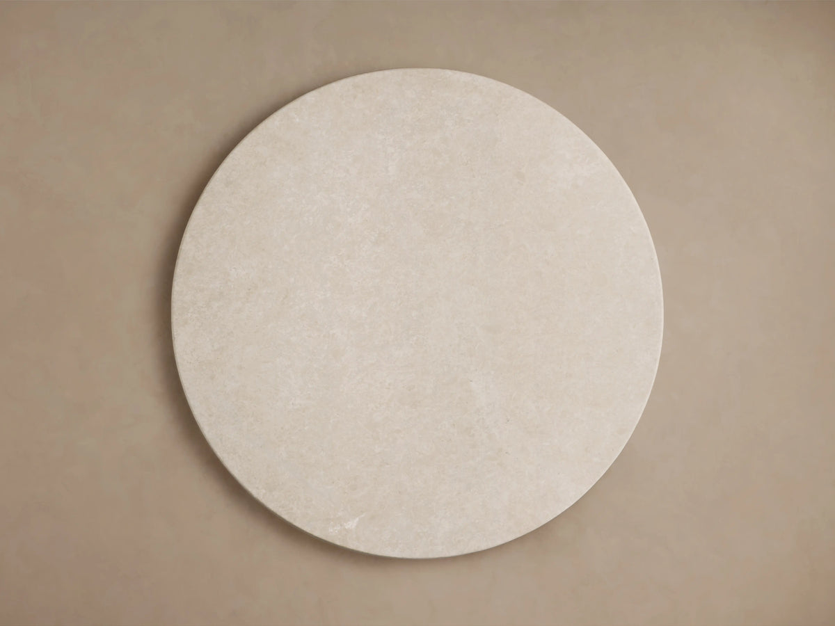 Saint Germain Round Stone Dining Table with a creamy marble top, showcasing smooth, rounded edges and natural variations.