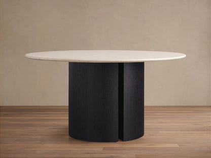 Round dining table with a smooth cream stone top and dual vertical dark ebony base on a wooden floor background.