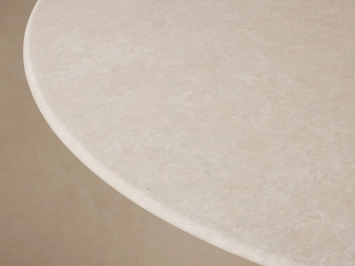 Front view of the Saint Germain Round Stone Dining Table with Launette Base, featuring a light stone top and gold-toned hourglass base.