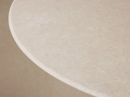Front view of the Saint Germain Round Stone Dining Table with Launette Base, featuring a light stone top and gold-toned hourglass base.