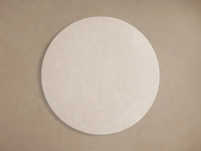Close-up of the beige honed stone top of the Saint Germain Round Stone Dining Table with Launette Base.