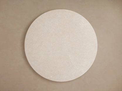 Saint Germain Round Stone Dining Table featuring a white marble top with unique patterns and a sleek, curved gold-toned steel base on wooden floor.
