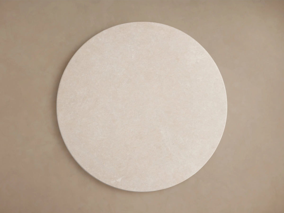 Round cream marble tabletop of the Saint Germain Dining Table, showing close-up of natural variations and smooth edges.