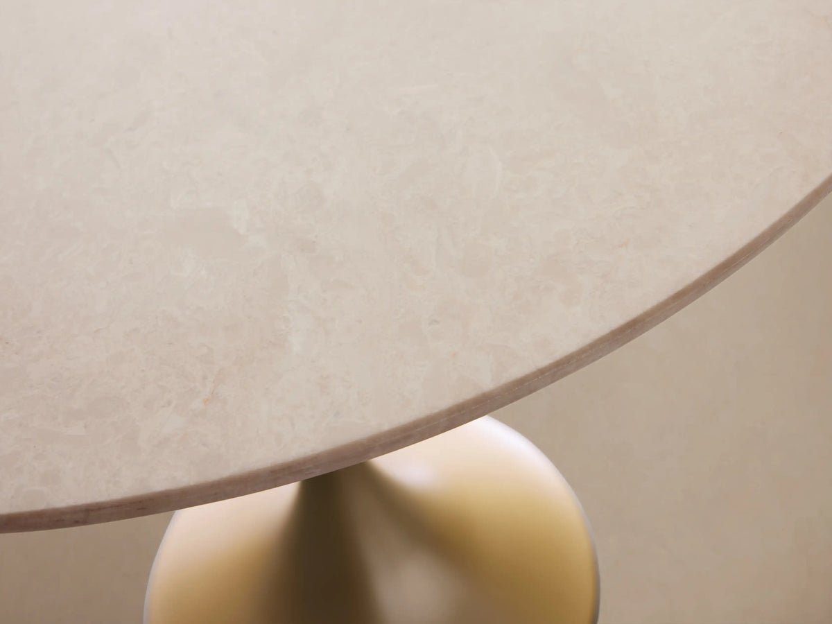 Saint Germain Bar Table with a round white Carrara marble top and a sleek gold steel base on a wooden floor.