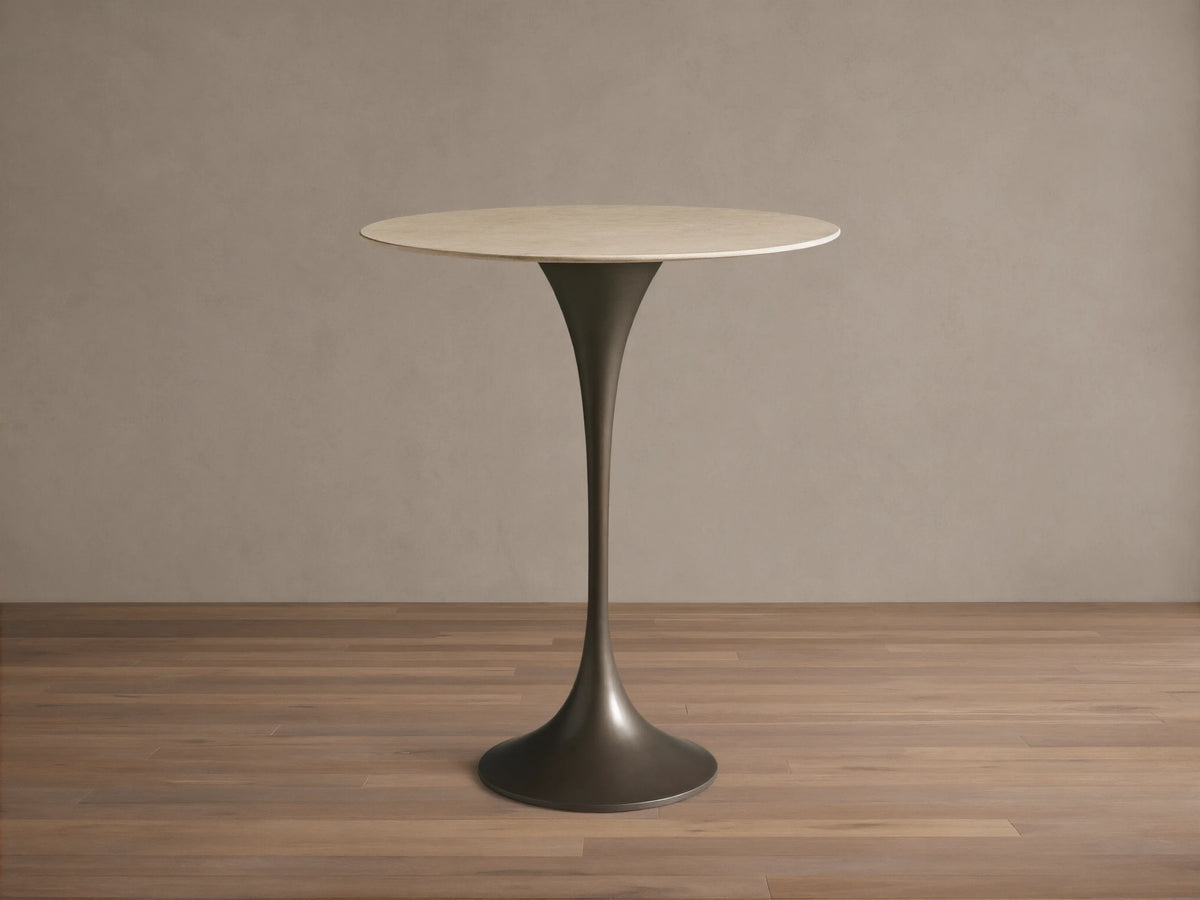 Front view of Saint Germain Counter Table with a round light stone top and dark trumpet-shaped steel base.