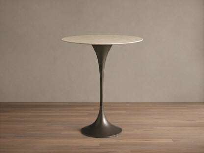 Front view of Saint Germain Counter Table with a round light stone top and dark trumpet-shaped steel base.