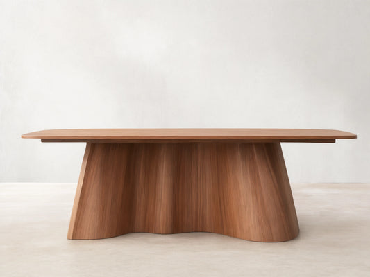 Cortina Dining Table made of American walnut. Features a smooth rectangular top and a unique fluted, wavy pedestal base.