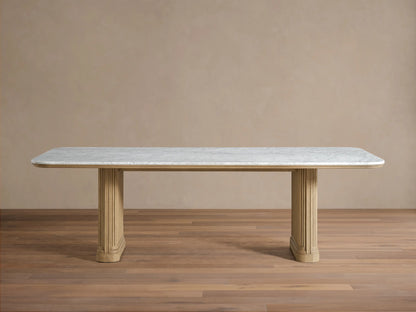 Front view of the Coventry Dining Table with a white Carrara marble top, supported by two oak wood bases with reeded detailing.