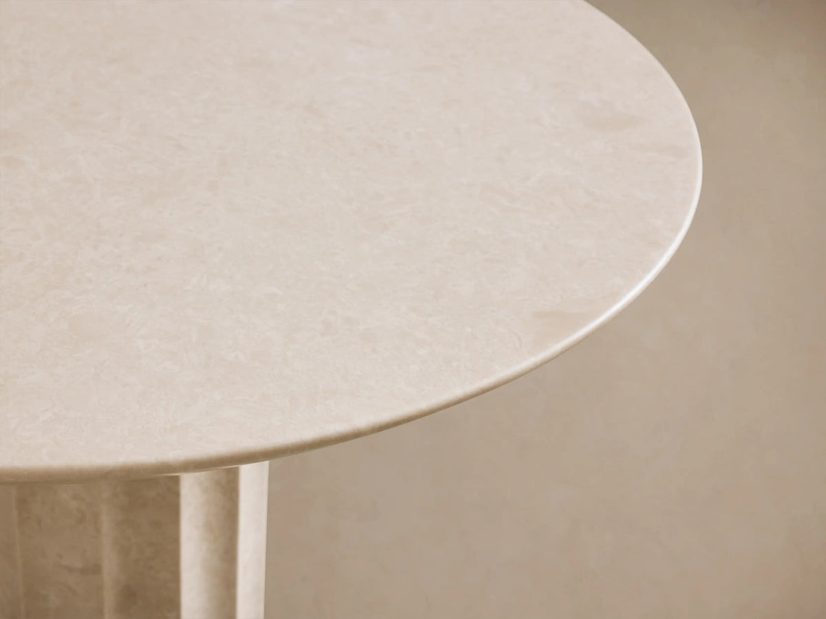 Danae Bistro Table, round light beige marble with a fluted pedestal base, against a neutral wall on a wooden floor.