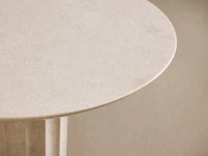 Danae Bistro Table, round light beige marble with a fluted pedestal base, against a neutral wall on a wooden floor.