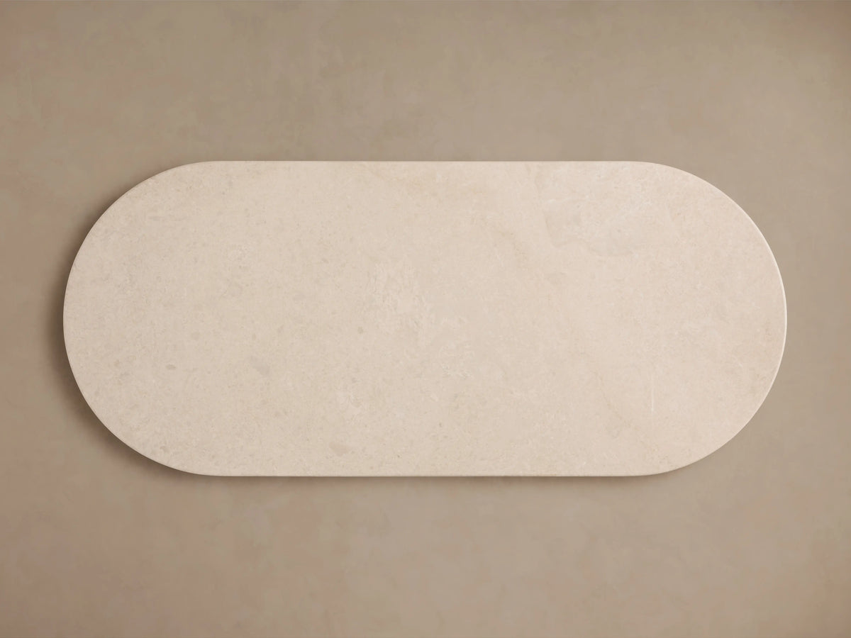 Danae Stone Dining Table with cream marble top, rounded edges, and textured cylindrical base against a neutral background.
