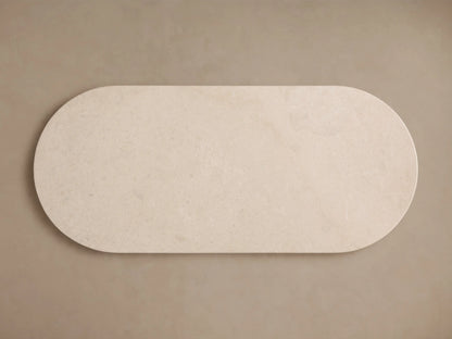 Danae Stone Dining Table with cream marble top, rounded edges, and textured cylindrical base against a neutral background.