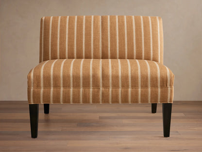 Eaton Bench upholstered in warm brown fabric with light vertical stripes, on four dark, tapered wooden legs. Front view.