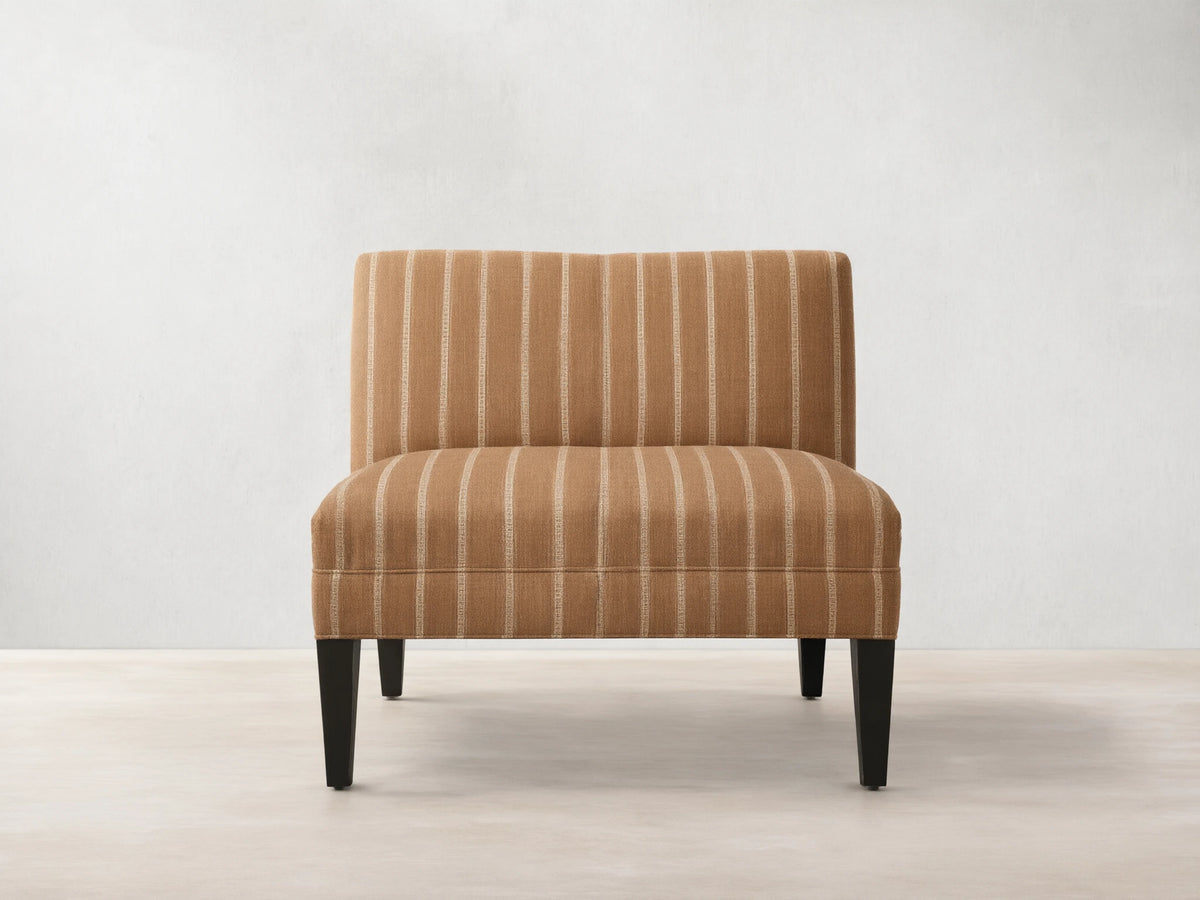 Eaton Bench upholstered in warm brown fabric with light vertical stripes, on four dark, tapered wooden legs. Front view.