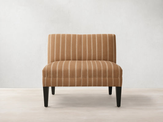 Eaton Bench upholstered in warm brown fabric with light vertical stripes, on four dark, tapered wooden legs. Front view.