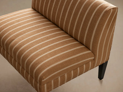 Eaton Bench, upholstered in brown fabric with vertical white stripes, dark wooden legs, angled front view.