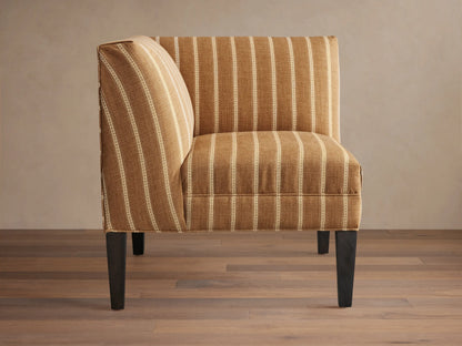 Eaton Corner chair upholstered in brown fabric with thin white vertical stripes, on dark wooden legs, angled.