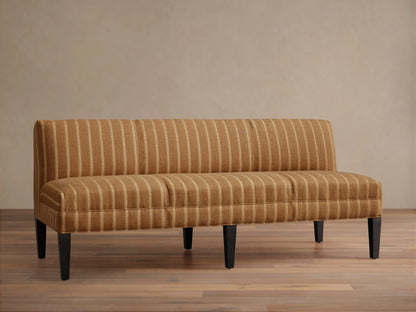 Eaton Settee, golden-brown upholstered with vertical light stripes, dark tapered legs, shown frontally against a light wall.