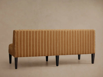 Angled close-up of Eaton Settee, warm brown fabric with cream pinstripes, dark wood leg on left.