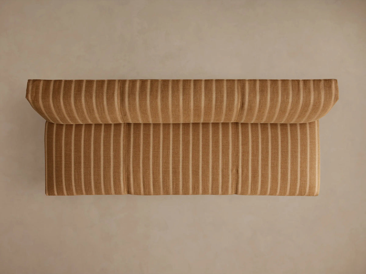 Back view of Eaton Settee upholstered in golden-brown fabric with light vertical stripes, featuring dark wooden legs.
