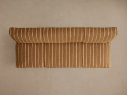Back view of Eaton Settee upholstered in golden-brown fabric with light vertical stripes, featuring dark wooden legs.